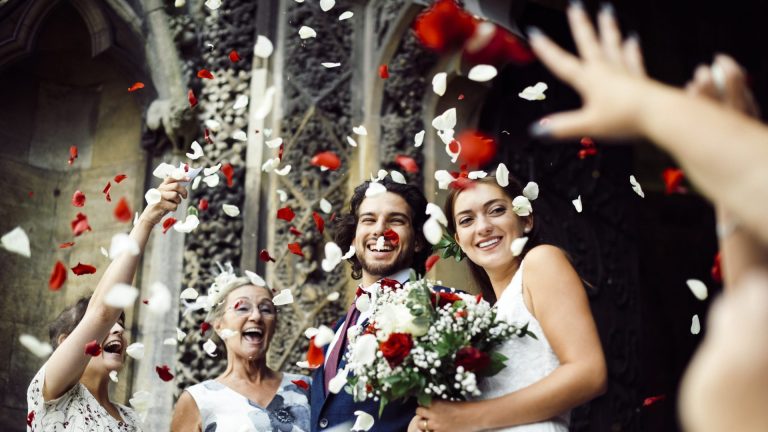 Contact 8 Family throwing rose petals at the newly wed bride and groom